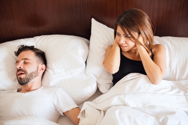 husband snoring while wife putting hands on ear
